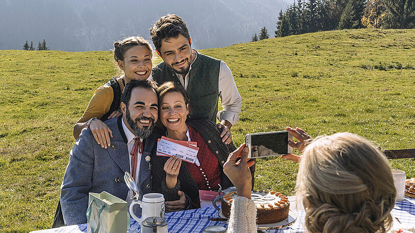 "Servus, Schwiegersohn!": Toni (Adnan Maral, sitzend) mit Ehefrau Anne (Jule Ronstedt), Tochter Franzi (Lena Meckel, stehend) und Schwiegersohn Osman (Aram Arami)