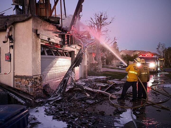 Feuerwehrleute löschen ein brennendes Haus im südkalifornischen Santa Clarita.