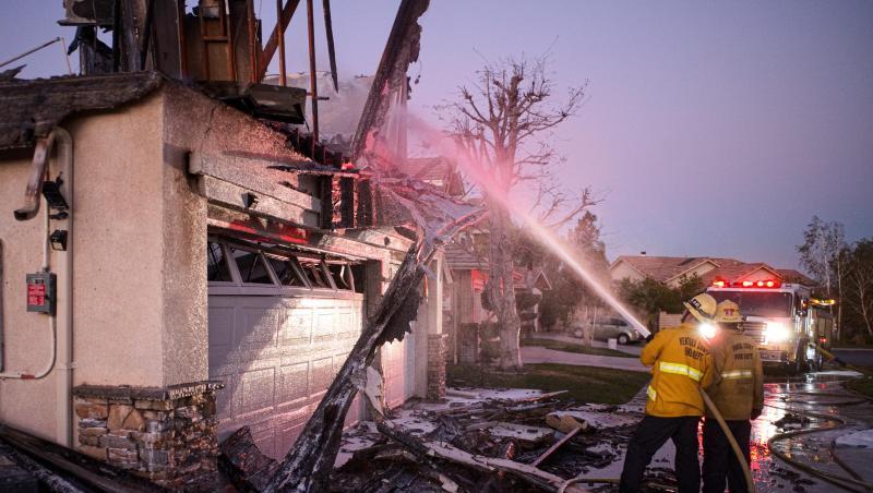 Feuerwehrleute löschen ein brennendes Haus im südkalifornischen Santa Clarita. Feuerwehrleute löschen ein brennendes Haus im südkalifornischen Santa Clarita.