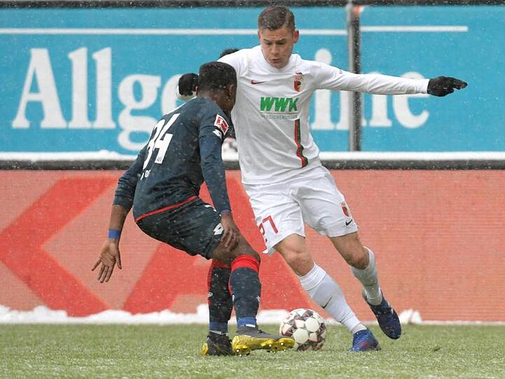 Augsburgs Alfred Finnbogason (r) und Ridle Baku von Mainz kämpfen um den Ball. Foto: Stefan Puchner