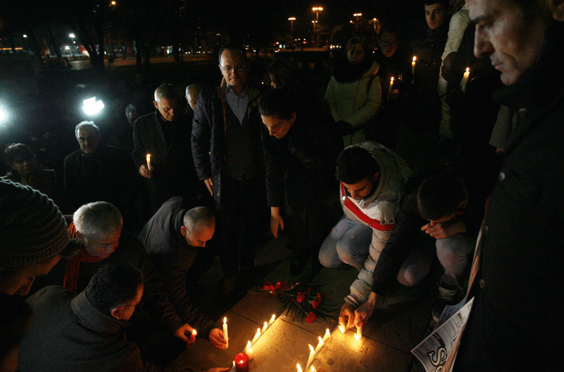Kerzen und Bilder der Opfer haben diese Trauernden in Tirana (Albanien) hingestellt.