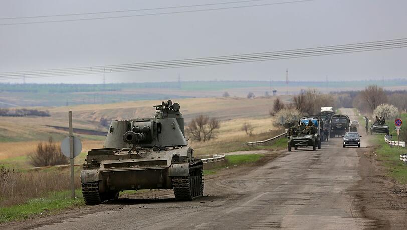Russische Militärfahrzeuge fahren eine Straße in der Nähe von Mariupol entlang.