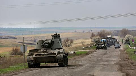 Russische Militärfahrzeuge fahren eine Straße in der Nähe von Mariupol entlang.