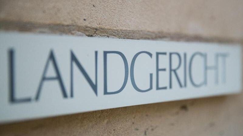 Ein Schild mit der Aufschrift "Landgericht" hängt am Landgericht in Ansbach. Foto: Daniel Karmann/dpa/Archivbild