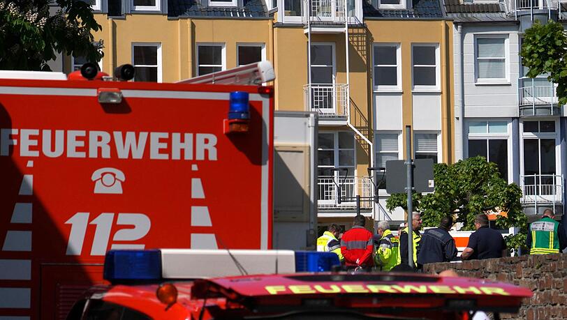 Rettungswagen, Polizisten und Polizeifahrzeuge stehen in der N&auml;he des Einsatzortes.