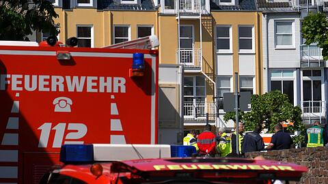 Rettungswagen, Polizisten und Polizeifahrzeuge stehen in der N&auml;he des Einsatzortes.