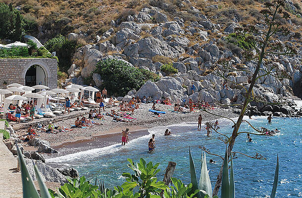 Urlauber und Sonnenhungrige tummeln sich an einem Strand auf der Ferieninsel Hydra (Griechenland). Urlauber und Sonnenhungrige tummeln sich an einem Strand auf der Ferieninsel Hydra (Griechenland).