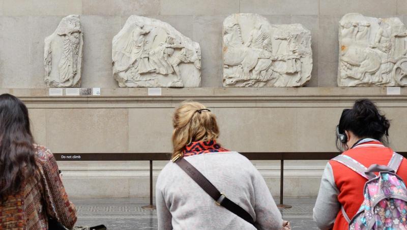 Besucher des British Museum in London sitzen vor Parthenon-Friesteilen. Besucher des British Museum in London sitzen vor Parthenon-Friesteilen.