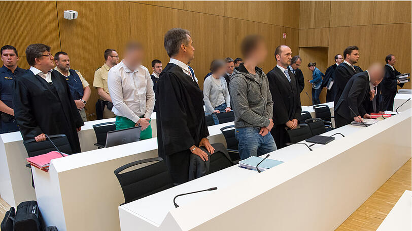 Die Angeklagten (gepixelt) stehen zu Beginn des Prozesses um den Doppelmord von Höfen im Hochsicherheits-Gerichtssaal der Justizvollzugsanstalt Stadelheim.