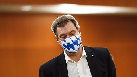 Markus Söder, Ministerpräsident von Bayern, trägt eine Gesichtsmaske mit dem weiß-blauen Rautenmuster Bayerns. Foto: Markus Schreiber/AP-Pool/dpa/Archivbild
