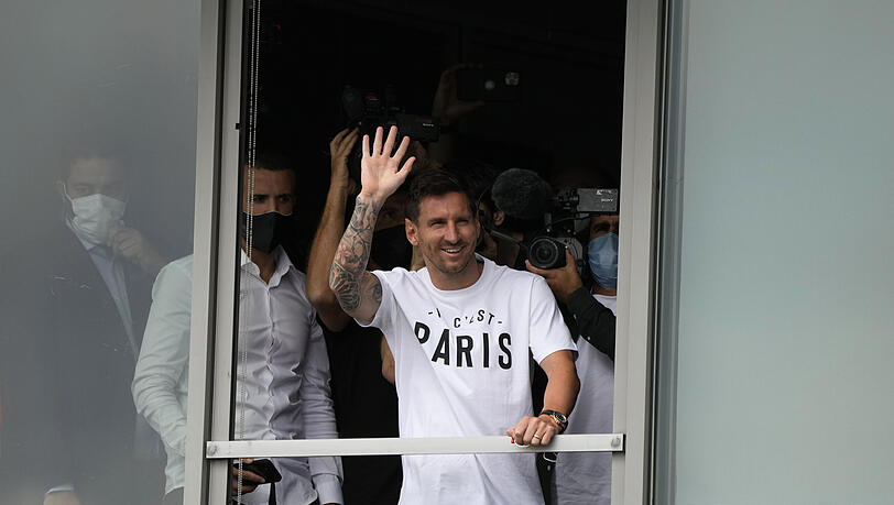 Lionel Messi winkt den Fans aus einem Fenster zu, nachdem er auf dem Flughafen Le Bourget gelandet ist.