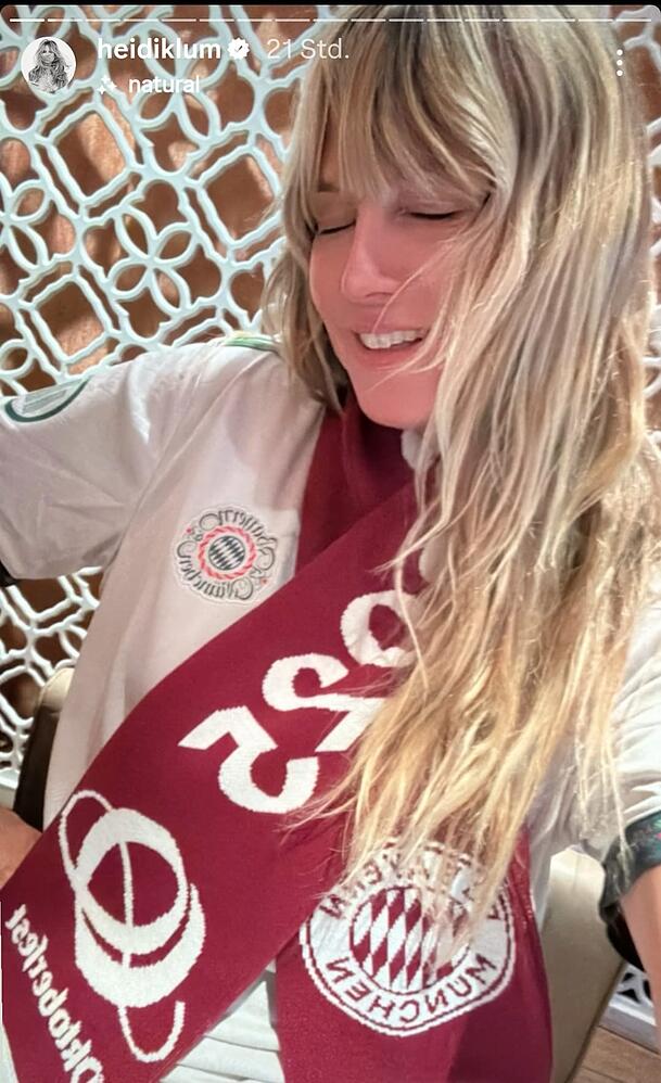 Müde, aber glücklich: Heidi Klum mit Bayern-Schal im Restaurant.