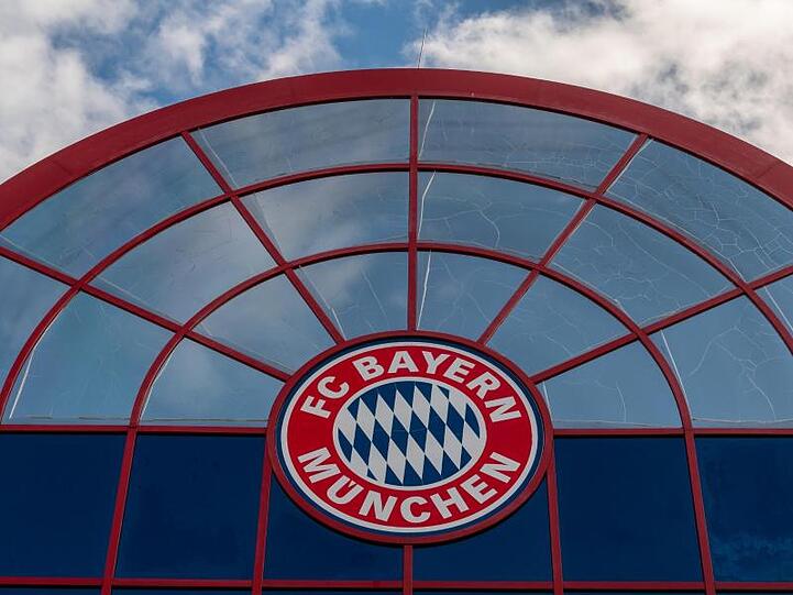 Das Logo des FC Bayern München über der Einfahrt zum Gelände des Fußball-Bundesligisten. Foto: Peter Kneffel/dpa/Archivbild
