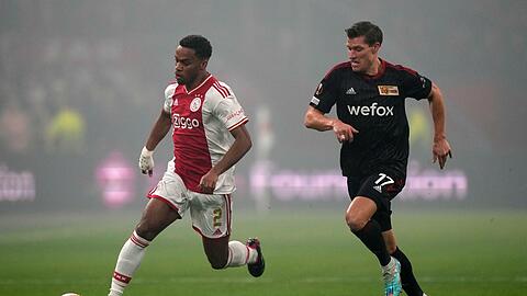 Der Unioner Kevin Behrens (r) im Laufduell mit Jurrien Timber von Ajax Amsterdam.
