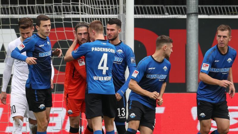 Paderborns Torwart Jannik Huth (3.v.l) hat den Elfmeter von Ingolstadts Stefan Kutschke (l) gehalten und wird von Jasper van der Werff (4.v.l) geherzt.
