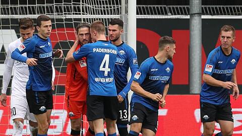 Paderborns Torwart Jannik Huth (3.v.l) hat den Elfmeter von Ingolstadts Stefan Kutschke (l) gehalten und wird von Jasper van der Werff (4.v.l) geherzt.