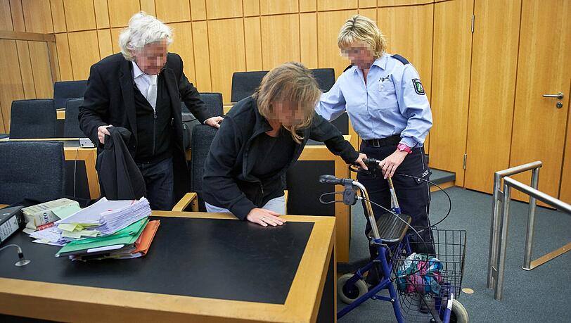 Die Angeklagte, Katja R., gestützt von einem Rollator und einer Justizmitarbeiterin in Begleitung ihres Anwaltes Siegmund Benecken (l) im Saal des Landgerichts in Münster. (Archivbild) Die Angeklagte, Katja R., gestützt von einem Rollator und einer Justizmitarbeiterin in Begleitung ihres Anwaltes Siegmund Benecken (l) im Saal des Landgerichts in Münster. (Archivbild)