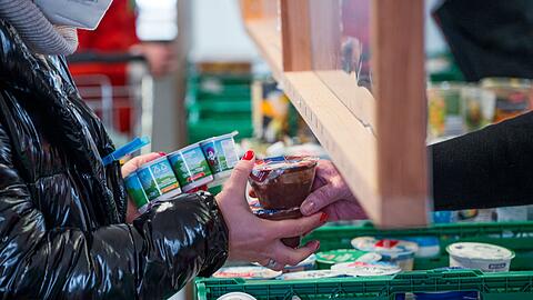 Eine Kundin (l) der Tafel Coburg bekommt Joghurt und Pudding. Der Landesverband Tafel Bayern e. V. besteht aus insgesamt 171 Mitgliedstafeln. (Archivbild)