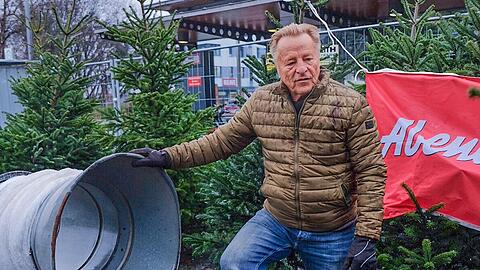 Rupi Bauer wartet am Weihnachtsbaum-Trichter, während sein Sohn Marko sich bereits eine Tanne schnappt. Mit wenigen Handgriffen zeigen die beiden, wie eingespielt sie sind