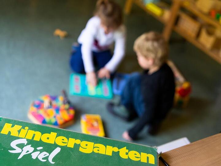 Ein Junge und ein Mädchen spielen in einem Kindergarten auf dem Boden. Foto: Monika Skolimowska/zb/dpa/Archivbild