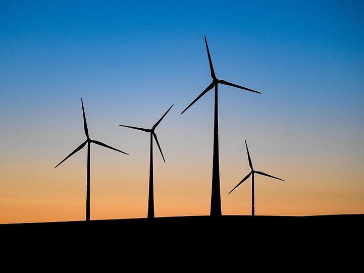 Windenergieanlagen vor dem farbenprächtigen Morgenhimmel. Foto: Patrick Pleul/Archiv