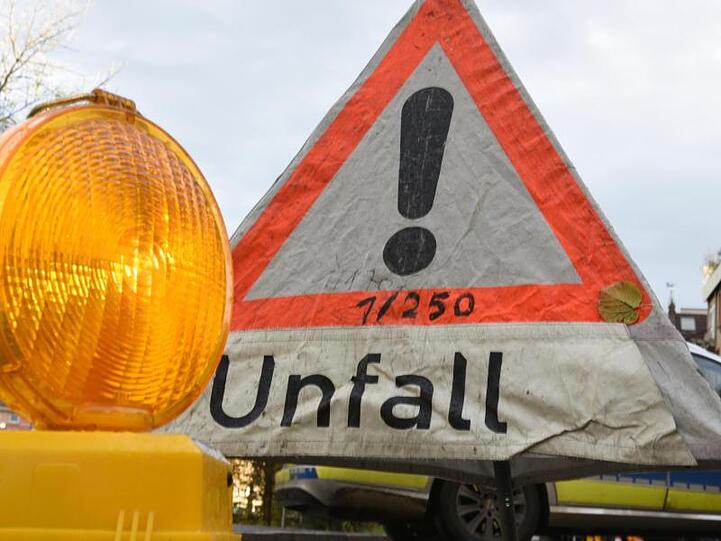 Ein Warnlicht steht vor einem Polizeiwarndreieck mit der Aufschrift "Unfall". Foto: Patrick Seeger/Archiv