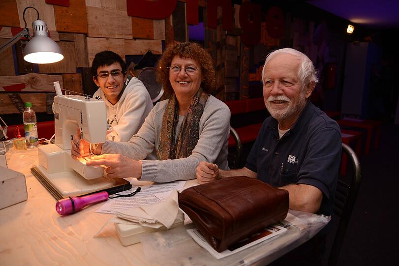 Die Freude ist groß, die Nähmaschine läuft wieder (v.l.): Suar Mustafa, Liselotte Keipel und Werner Kunzendorf im Repair Café auf dem Tollwood.