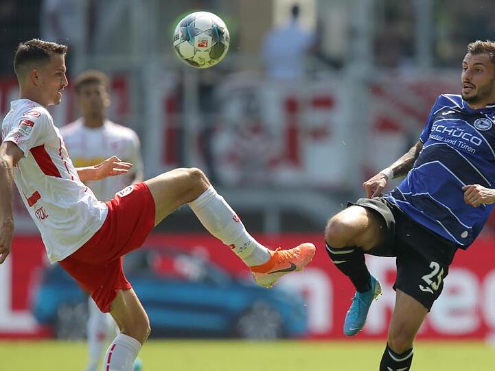 Der Regensburger Sebastian Stolze und der Bielefelder Jonathan Clauss (l-r.) im Zweikampf um den Ball. Foto: Daniel Karmann