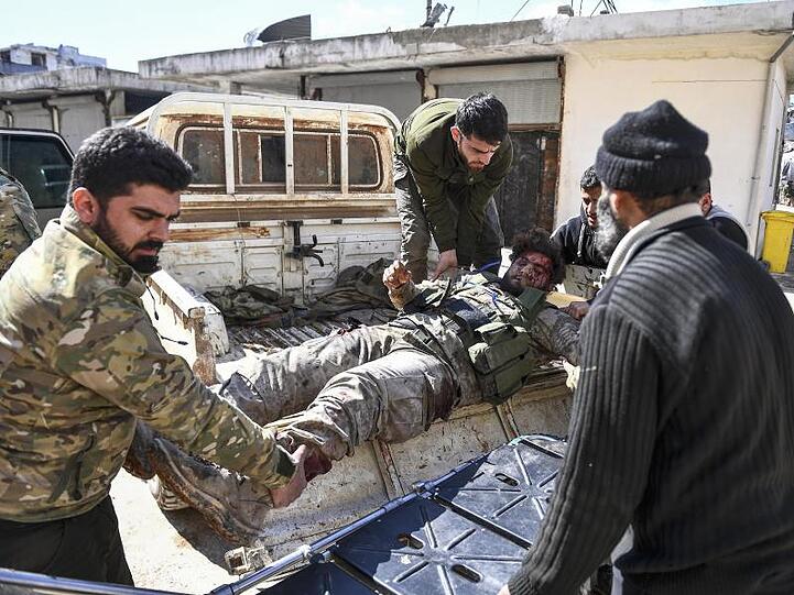 Von der Türkei unterstützte Oppositionskämpfer transportieren einen verwundeten Kameraden. Am Dienstag wurde ein weiterer türkischer Soldat in der Provinz Idlib getötet.