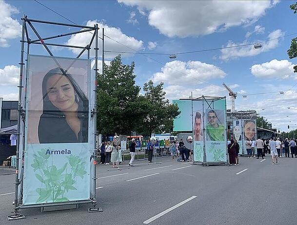 Aufsteller mit &uuml;berlebensgro&szlig;en Fotos der Get&ouml;teten stehen am Weg zum Gedenkort.