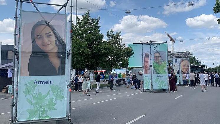 Aufsteller mit &uuml;berlebensgro&szlig;en Fotos der Get&ouml;teten stehen am Weg zum Gedenkort.