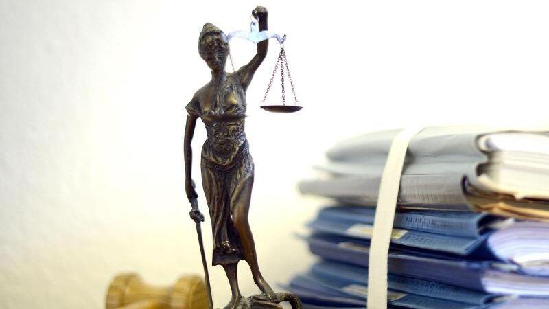 Justitia mit Holzhammer und Aktenstapel. Foto: Volker Hartmann/Archivbild