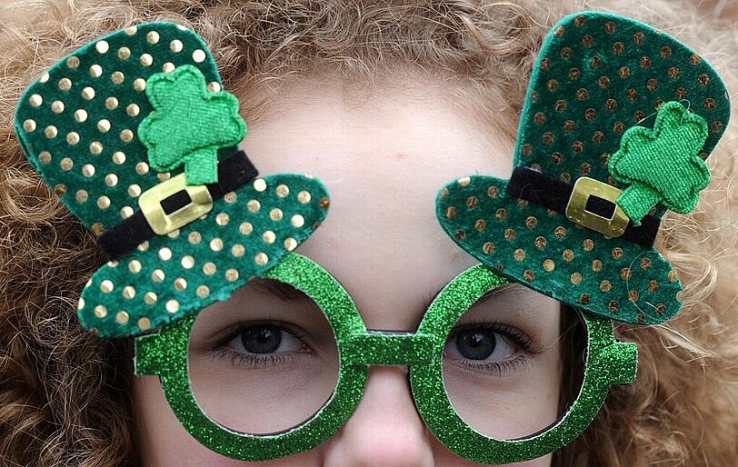 Voller Durchblick: Eine Frau trägt bei der St. Patrick's Day-Parade eine grüne Brille mit dem Leprechaun-Hut und Kleeblättern.