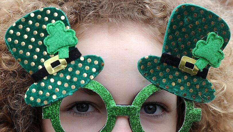 Voller Durchblick: Eine Frau trägt bei der St. Patrick's Day-Parade eine grüne Brille mit dem Leprechaun-Hut und Kleeblättern.