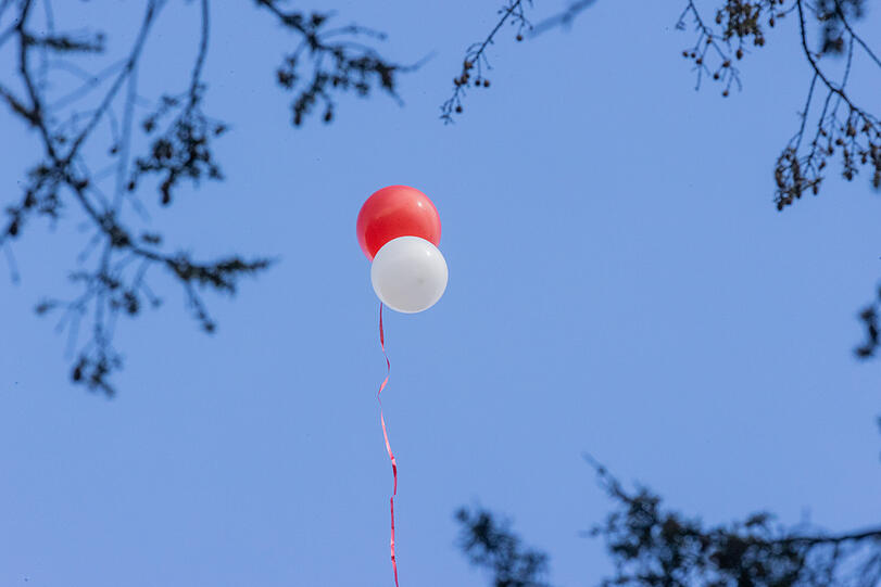 Luftballons in rot und weiß steigen am Melaten Friedhof in den Himmel. Willi Herren war am 20. April verstorben.
