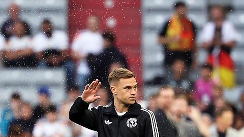 Kapitän Joshua Kimmich winkt nach der Ankunft im Münchner Stadion den Fans zu.