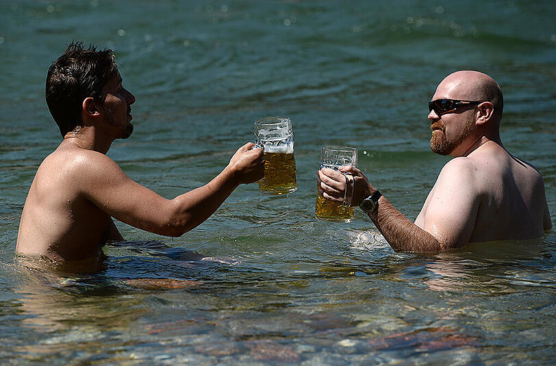 Prost! Diese zwei ließen sich ihr Bier letzte Woche gleich in der Isar schmecken. Solche Späße sind spätestens zum Wochenende wieder drin.