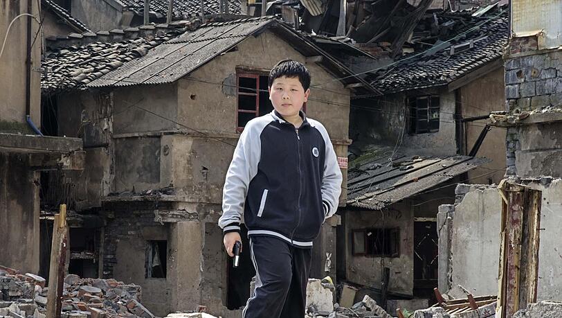 "Mit großer Spannung und Anteilnahme verfolgte ich die weitere Entwicklung des Viertels in unmittelbarer Nachbarschaft zum Ort meiner Kindheit. Bei meinen letzten Besuch im Frühjahr 2013 in Shanghai waren bereits über 100 Behausungen der Bewohner abgerissen. Beim Studieren der Ruinen und Wohnungen, die nun ihr Inneres nach außen gekehrt haben, beobachtete ich ein paar Jungen beim Guerilla-Spiel. Heute spielen sie vielleicht nur die Rolle der Rebellen, um Freiheit, Selbstbestimmung und Gerechtigkeit herzustellen; und morgen?" "Mit großer Spannung und Anteilnahme verfolgte ich die weitere Entwicklung des Viertels in unmittelbarer Nachbarschaft zum Ort meiner Kindheit. Bei meinen letzten Besuch im Frühjahr 2013 in Shanghai waren bereits über 100 Behausungen der Bewohner abgerissen. Beim Studieren der Ruinen und Wohnungen, die nun ihr Inneres nach außen gekehrt haben, beobachtete ich ein paar Jungen beim Guerilla-Spiel. Heute spielen sie vielleicht nur die Rolle der Rebellen, um Freiheit, Selbstbestimmung und Gerechtigkeit herzustellen; und morgen?"