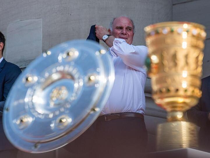 Uli Hoeneß, Präsident vom FC Bayern München, steht hinter der Meisterschale der Bundesliga und dem DFB-Pokal. Foto: Lino Mirgeler