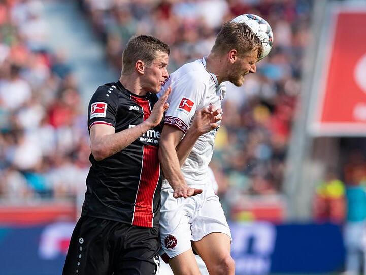 Leverkusens Sven Bender (l.) und Nürnbergs Hanno Behrens kämpfen um den Ball. Foto: Guido Kirchner
