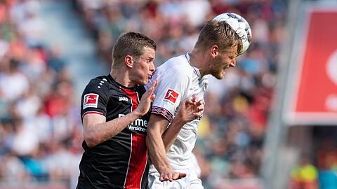 Leverkusens Sven Bender (l.) und Nürnbergs Hanno Behrens kämpfen um den Ball. Foto: Guido Kirchner