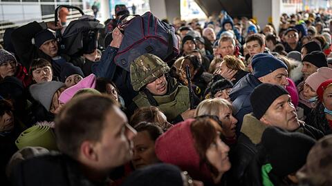 Ein ukrainischer Soldat versucht, die Menschenmenge aufzul&ouml;sen, die am Bahnhof von Kiew in einen Zug nach Lwiw steigen will.