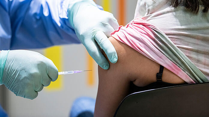 Eine Person wird im Impfzentrum von einem Impfarzt gegen das Coronavirus geimpft.