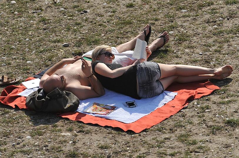 Klassiker: Mann schläft, Frau bildet sich. Und schöner als an der sonnigen Isar geht's kaum.