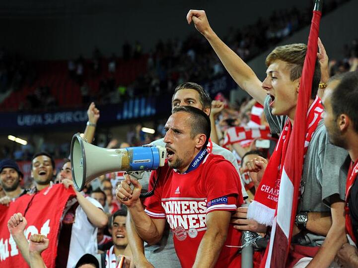 Münchens Franck Ribery (M) steht mit einem Megafon jubelnd inmitten der Münchner Fans. Foto: picture alliance / dpa/Archivbild