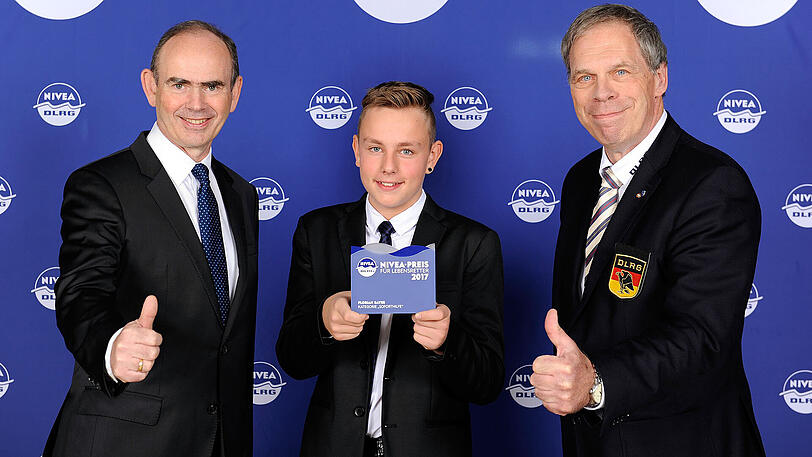 Iain Holding, General Manager Nivea Deutschland (links) und DLRG-Präsdident Achim Haag (rechts) loben das entschlossene Handeln von Florian Bayer: "Er ist ein wahrer Lebensretter 2017!"