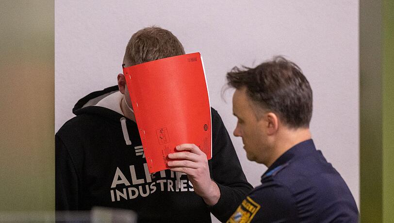 Der Angeklagte wird zum Prozess-Auftakt von Justizbeamten in den Gerichtssaal geführt.