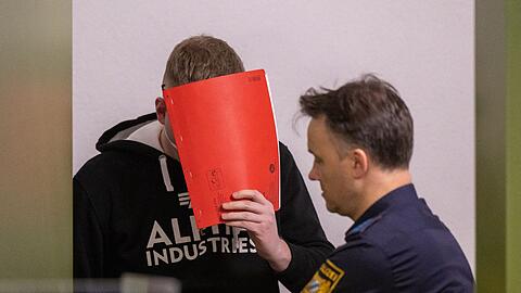 Der Angeklagte wird zum Prozess-Auftakt von Justizbeamten in den Gerichtssaal geführt.