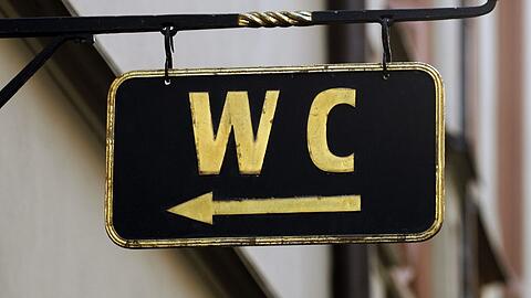 Ein Schild mit der Aufschrift "WC" und einem Hinweispfeil. (Archivbild)