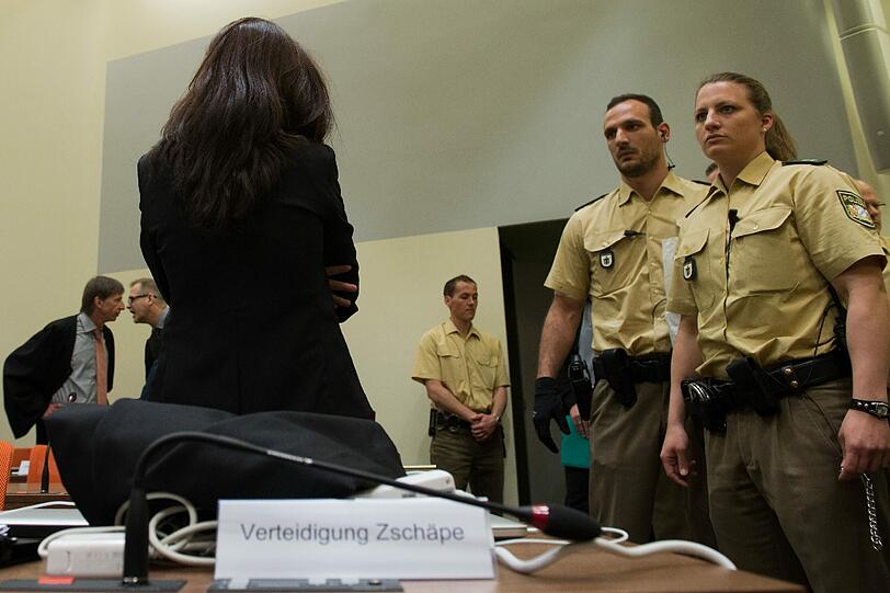 Die Angeklagte Beate Zschäpe (Mitte) steht zum Prozessauftakt im Gerichtssaal in München.
